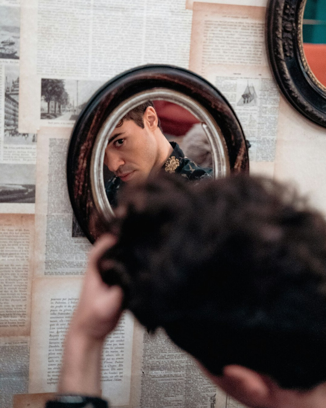 man adjusting tie in mirror