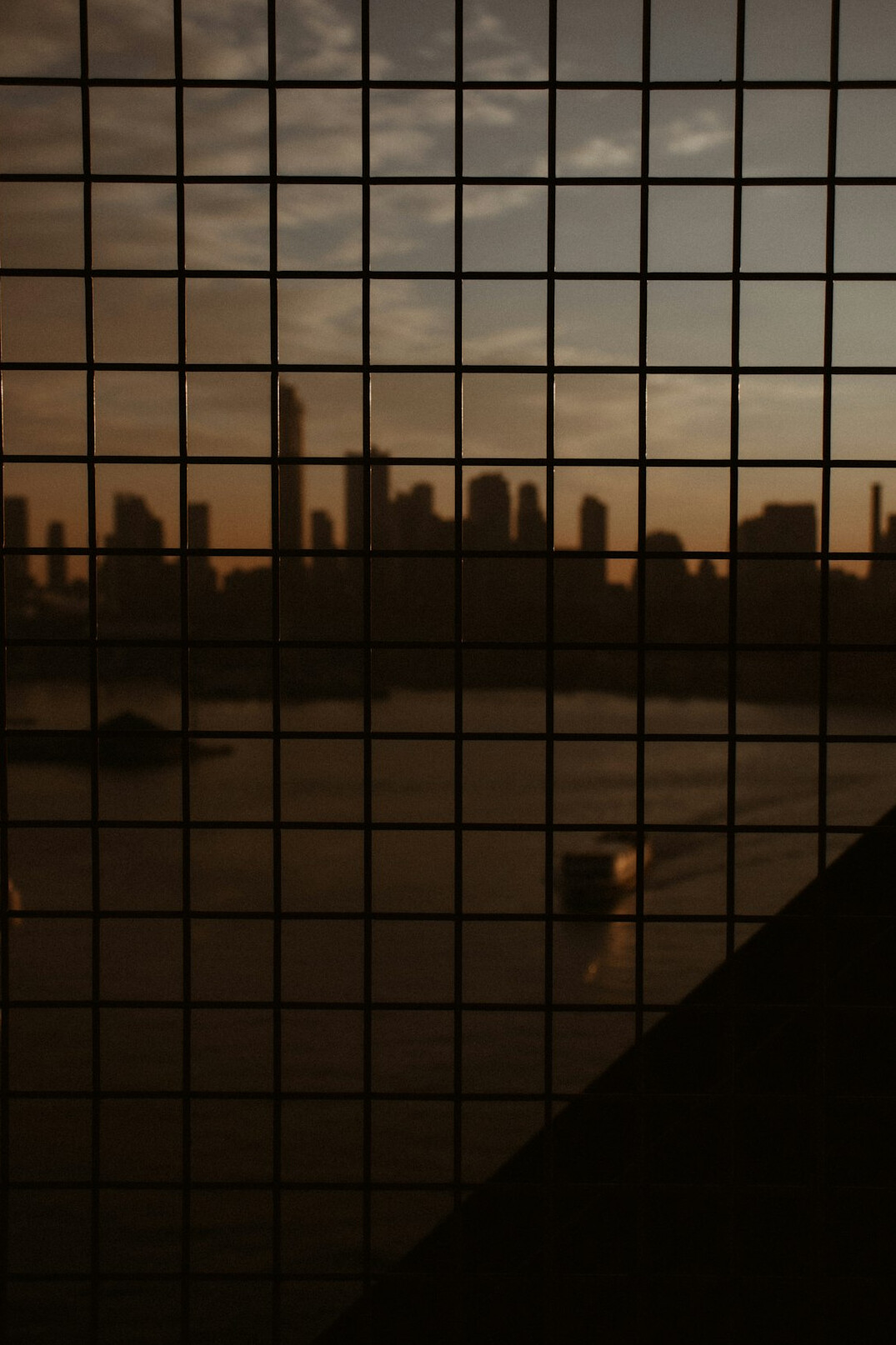 View of a city skyline through a window at sunset